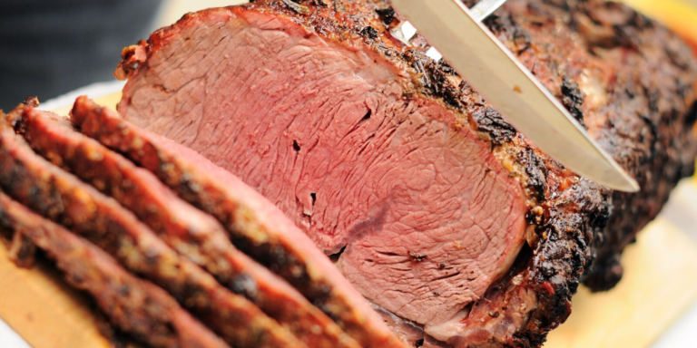 Slices being carved from a garlic-crusted prime rib roast